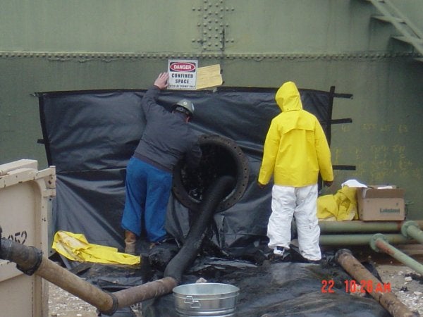 Workers in Safety Suits Managing Chemical Waste at Excel Industrial Group in Houston, TX
