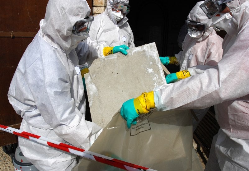 Workers in Protective Suits Removing Asbestos in Houston, TX