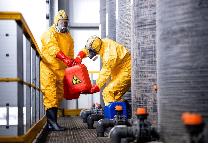 Chemical Factory Workers Carefully Handling Acidic & Caustic Biohazardous Waste in Houston, TX