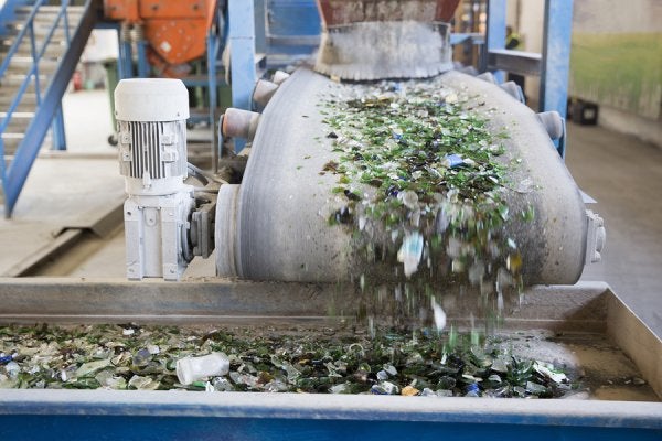 Workers in Safety Gear Disposing of Industrial Waste in Large Containers at Houston Facility